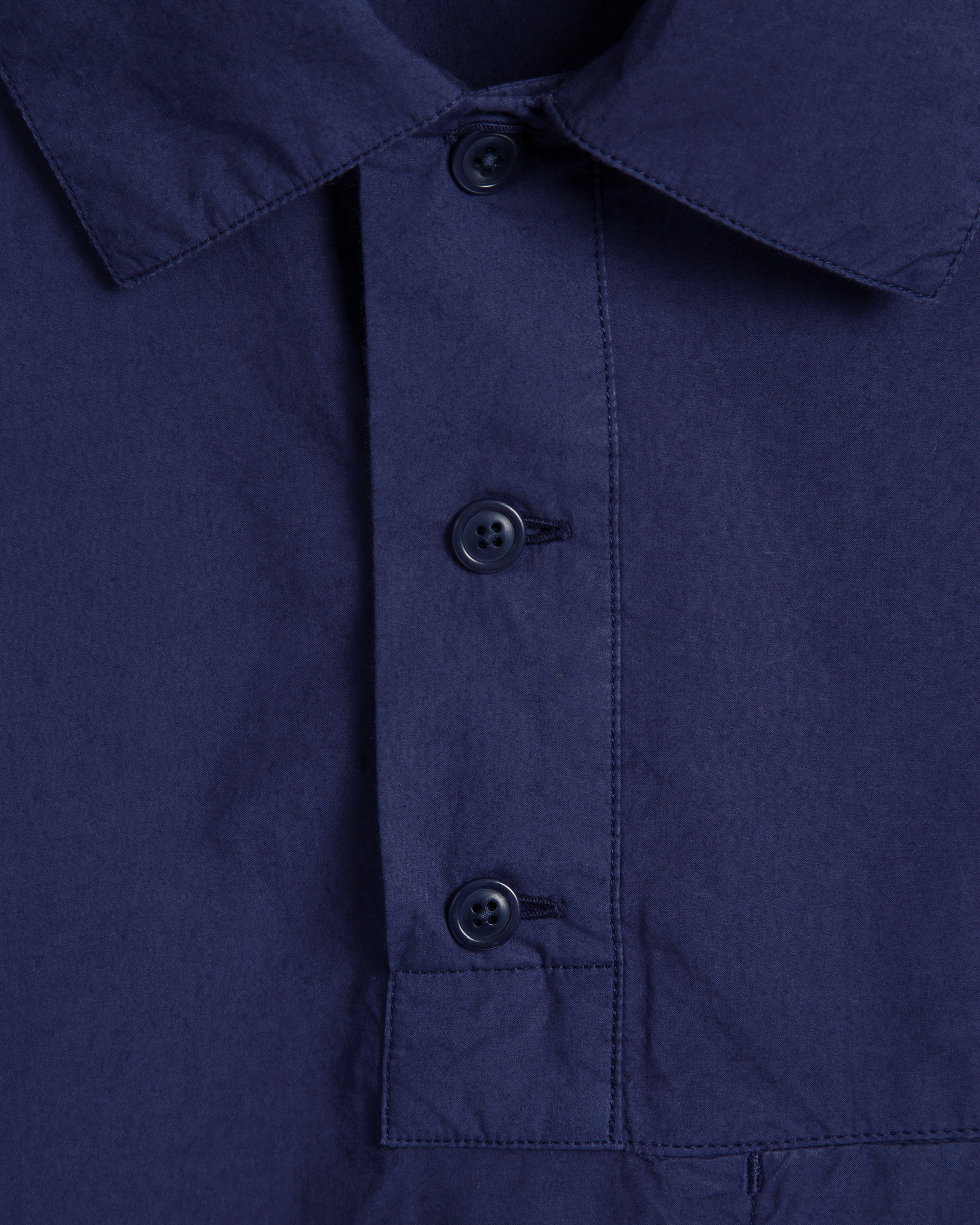 Close-up of a blue shirt with navy buttons 