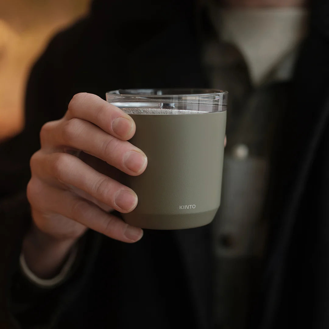 Person holding a Kinto mug with a blurred background