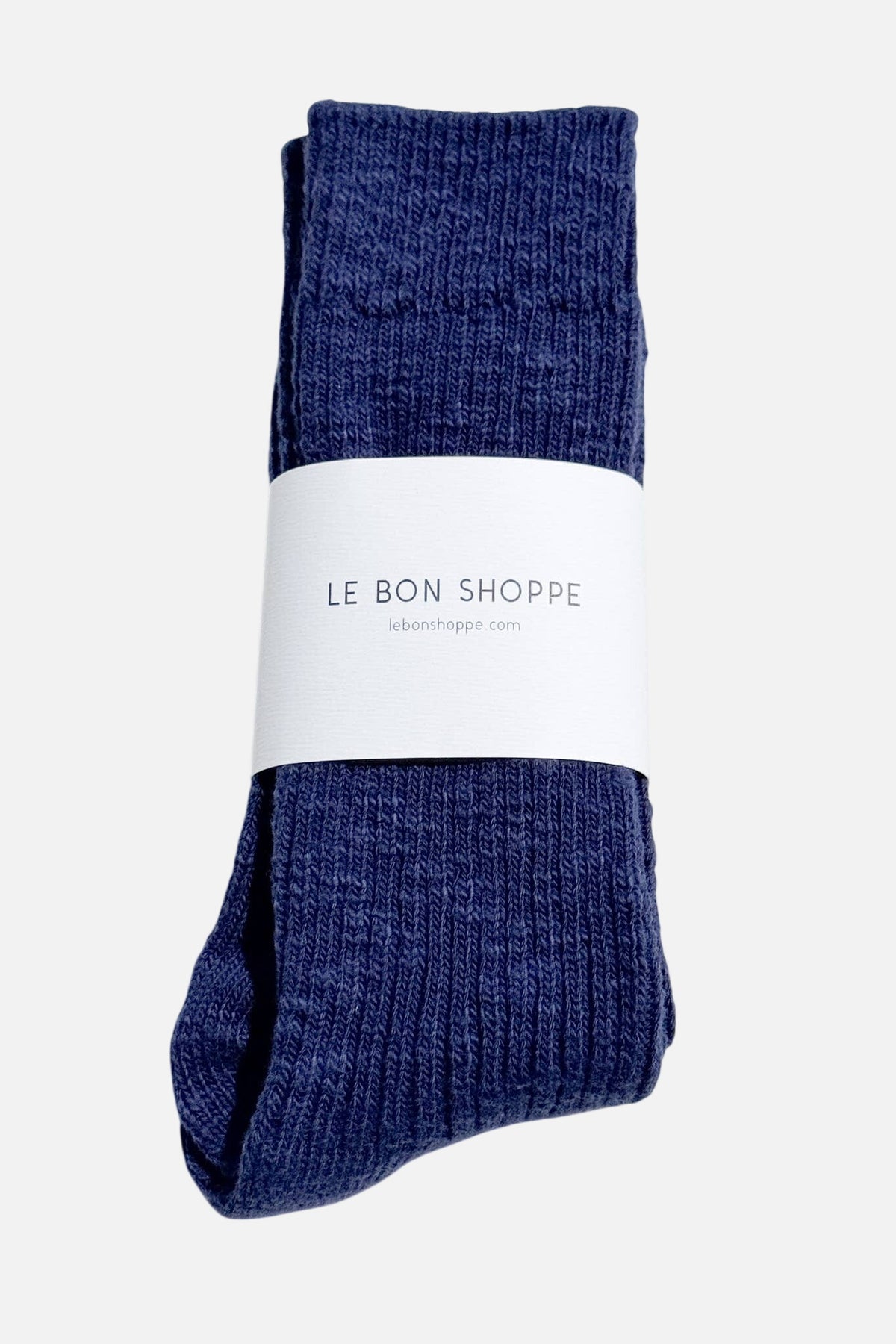 Pair of blue Le Bon Shoppe socks with a white label on a light grey background