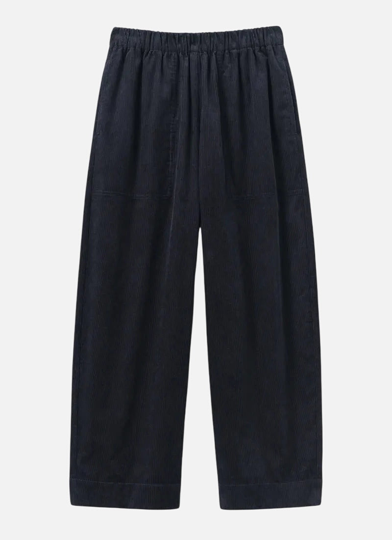 A pair of dark navy blue wide-leg trousers with an elastic waistband, displayed flat against a light gray background.
