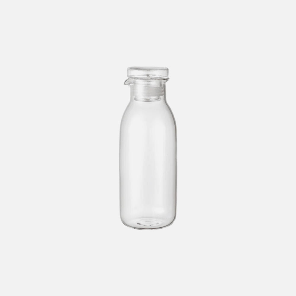 Clear glass dressing bottle on a white background