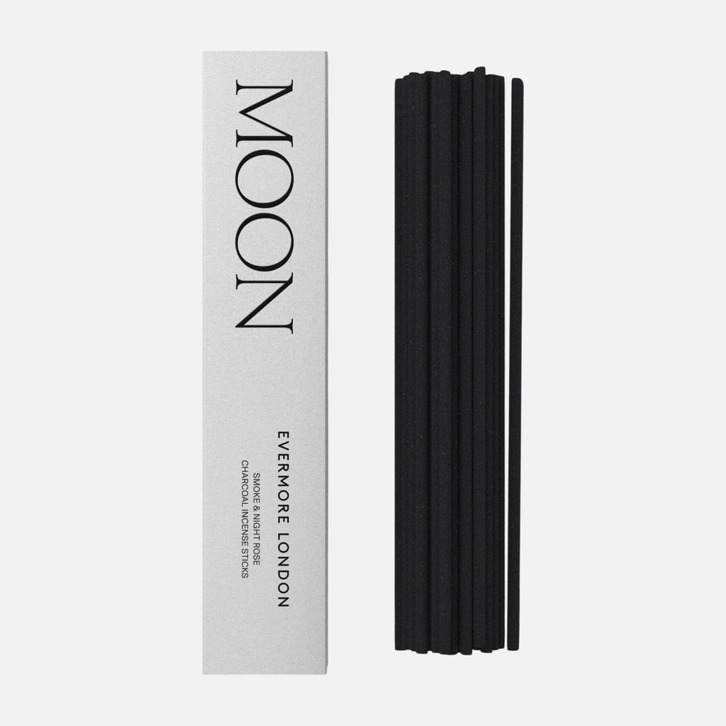 Black incense sticks next to a white box labeled 'MOON' by 'EVERMORE LONDON' on a white background.